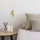 Le Petit LED Wandlampe 3000K an einer modernen Schlafzimmerwand neben einem Beistelltisch.