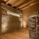 Moderner Raum mit steinerner Wand, Holzdetails und LED-Beleuchtung, Willkommen-Schild in der Nische.