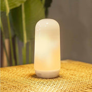 Lampe de table Candy à batterie avec effet flamme IP54 sur la table, éclaire doucement et sans fil.