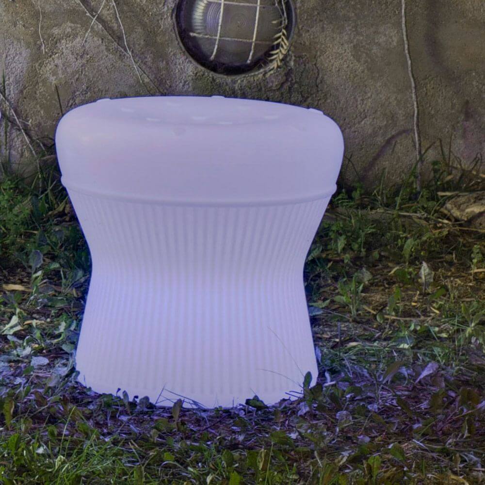 Corfu leuchtender LED Hocker mit Akku und Fernbedienung im Freien auf Gras unter sanftem Licht.