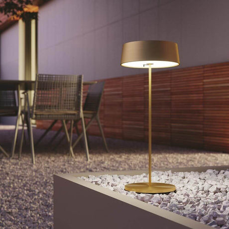 Lutec LED Akkuleuchte Cocktail Outdoor IP54 auf einem Tisch im Freien bei Nacht.