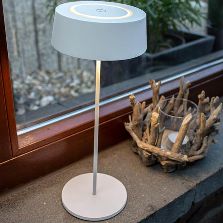 Lutec LED Akkuleuchte Cocktail Outdoor IP54 auf einem Tisch mit moderner Ästhetik und warmem Licht.