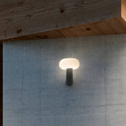 Pepita LED wall light Solar + sensor on a grey wall, creates warm light in a modern design.