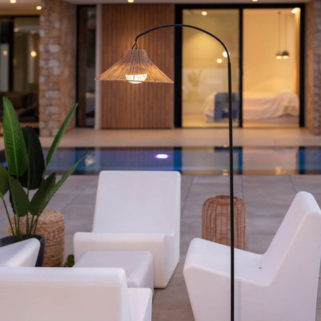 Lámpara de pie LED Niza con batería para exteriores IP54 junto a muebles de jardín blancos modernos en una piscina.