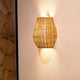 Saona Boho-Style LED Wand-Akkuleuchte aus Rattan IP54 an einer Wand installiert, aus handgewobenem Rattan.