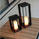 Siroco LED table & outdoor floor lamp flame effect in modern lantern design on a wooden table.