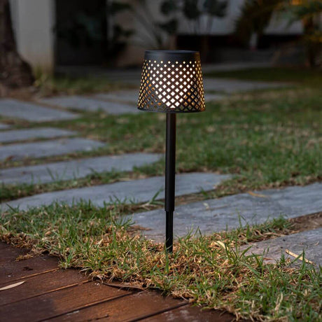 Floor and table lamp Greta 5 in 1 adjustable with ground spike Black in the garden on a path.