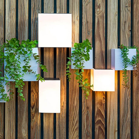 Wally LED Solar Lampada da Parete con Sensore di Movimento su Parete di Legno con Piante, elegante e funzionale.