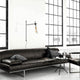 Retro-Wandleuchte Axis Schwarz an einer Wand über einem modernen Sofa in einem stilvollen Raum.