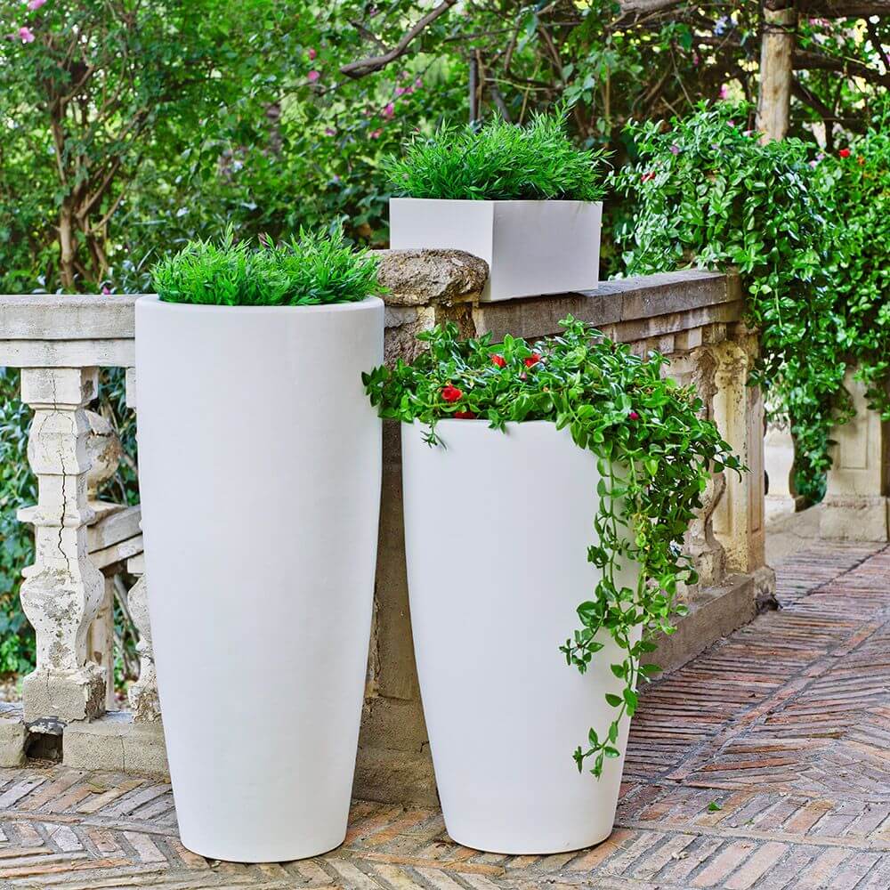 LED beleuchteter Dekotopf Bambu Big in weiß mit Pflanzen auf einer Terrasse.