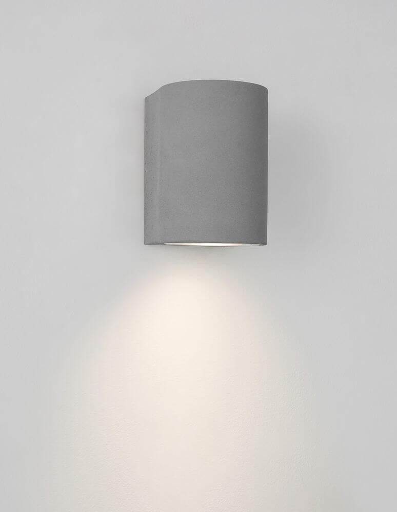 Lido Außenwandleuchte H 12cm GU10 Down IP65 in grau an einer Wand montiert mit dezentem Lichtschein.