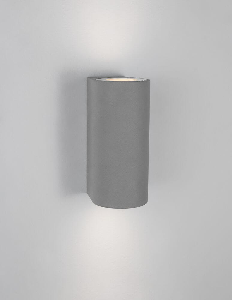 Lido Außenwandleuchte H 18cm GU10 Up & Down IP65 in modernem Beton-Design an der Wand montiert.