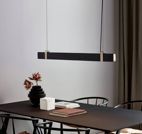 Lilt LED pendant light above a dining table with minimalist furnishings and elegant lighting.
