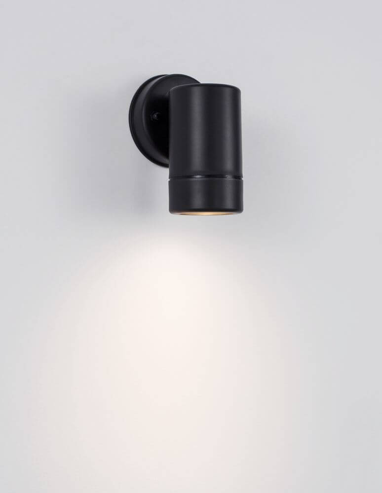 Limbio Außenwandleuchte H 12cm GU10 Down IP54 in mattem Schwarz an der Wand montiert mit warmem Lichtschein.