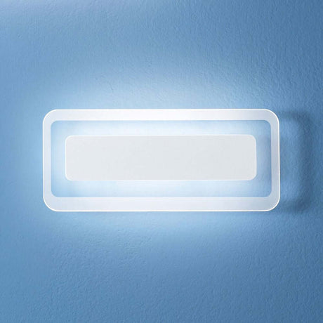 Antille LED-Wandleuchte Small an einer blauen Wand, modernes und elegantes Design für zeitgemäße Beleuchtung.
