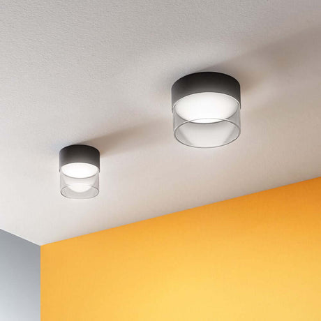 Two Crumb LED ceiling lights in a modern design on a ceiling with an orange wall.