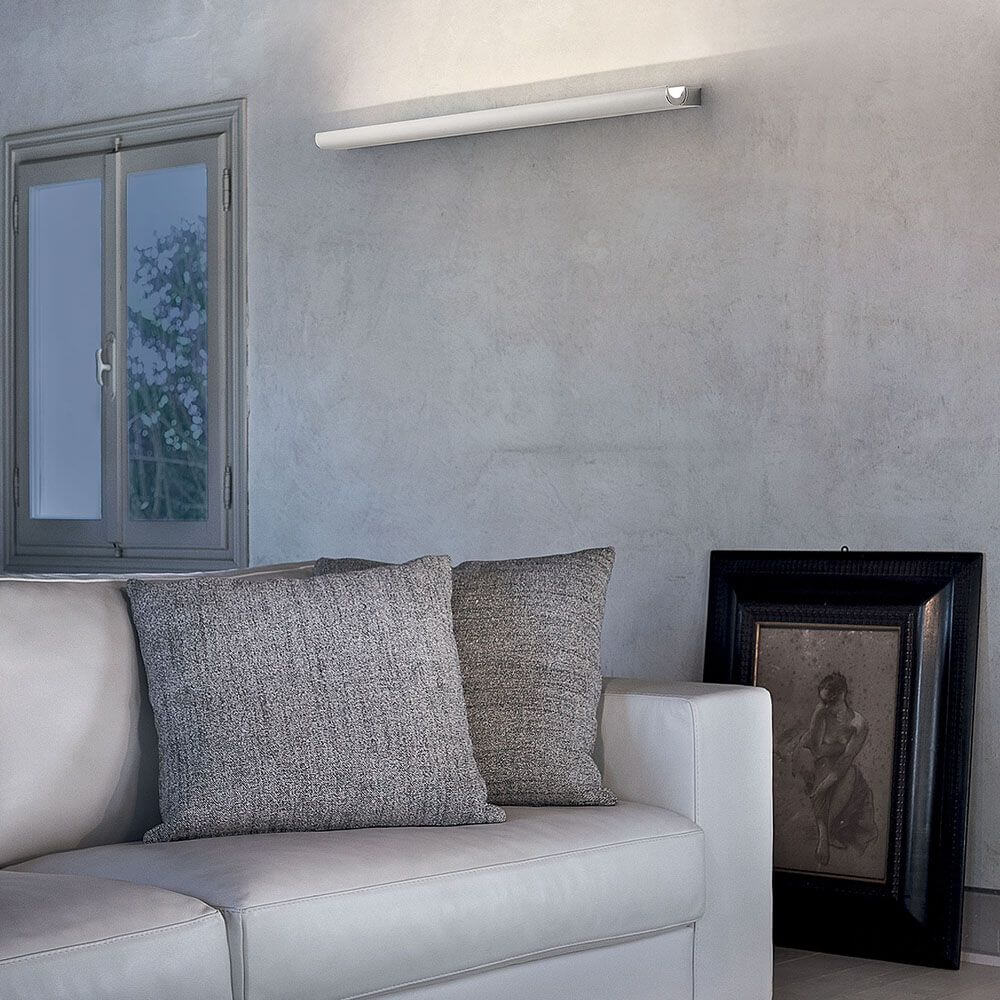 Moderne Wohnzimmeransicht mit Halfpipe L LED-Wandleuchte über einer weißen Couch.