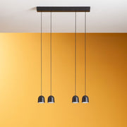 Minion P4 LED-Pendelleuchte mit drei modernen, schwarzen Lampenschirmen über gelbem Hintergrund.