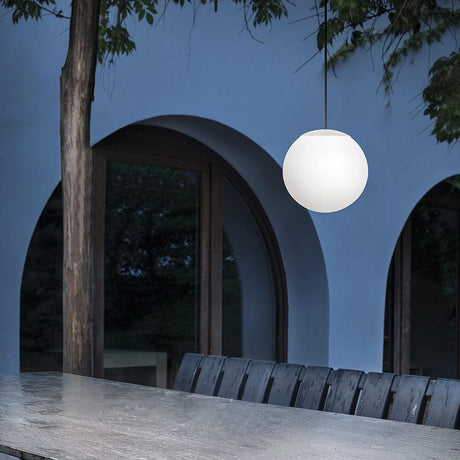 Oh! P65 LED-Pendelleuchte Large in modernem Außenbereich über Holztisch hängend.