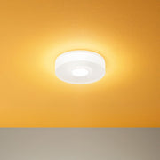 One to One S LED-Deckenleuchte an einer orangefarbenen Decke montiert.