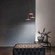 Poe P3 LED-Pendelleuchte über einem eleganten Hocker in modernem Raumdesign.