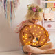 Kind trägt die Bär-Lampe aus Holz von Little Lights mit dimmbaren LED-Lichtern im Kinderzimmer.