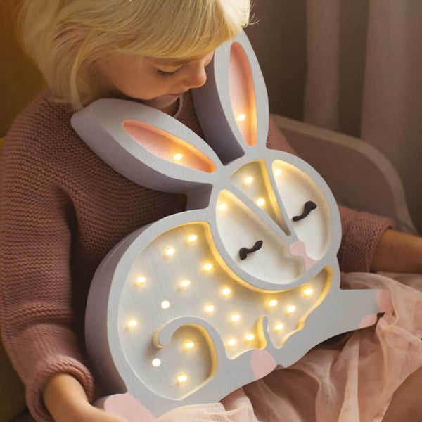 Kindermädchen mit einer Kinder Wand- & Tischleuchte Hase in Form eines Häschens mit sanften Lichtern.