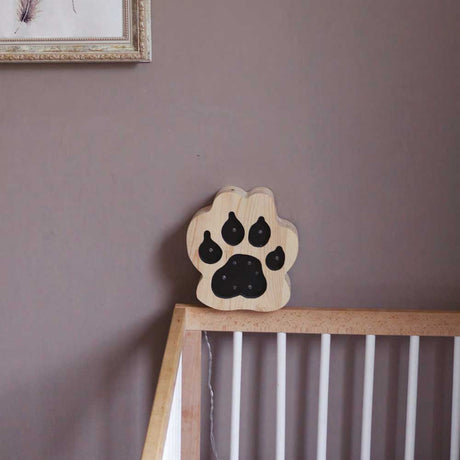 Kinder Wand- & Tischleuchte Pfote auf einem Tisch mit Holzgeländer, ideal für Kinderzimmer.