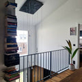 Lodes Rain LED Hängelampe Tropfen 7 Watt 1300 lm in modernem Wohnraum mit Bücherregal und Pflanzen