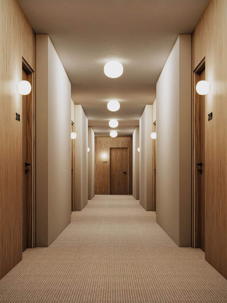 Bright hallway with wood paneling and Lodes Volum LED wall and ceiling light Dimmable IP54 White on the walls.