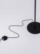 Detailaufnahme der Logos Stehlampe 3000K Schwarz mit schwarzem Kabel und Fuß.
