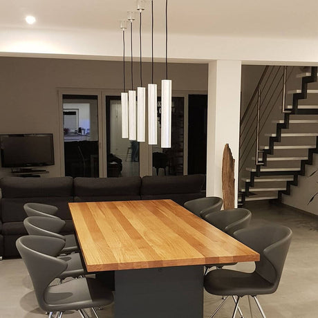 Look pendant light cylinder Ø 6cm genuine silver leaf above a dining table in a modern living space.