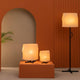 Luang Stehlampe und Tischleuchten in warmem Raum mit orangefarbenen Wänden und minimalistischer Einrichtung.