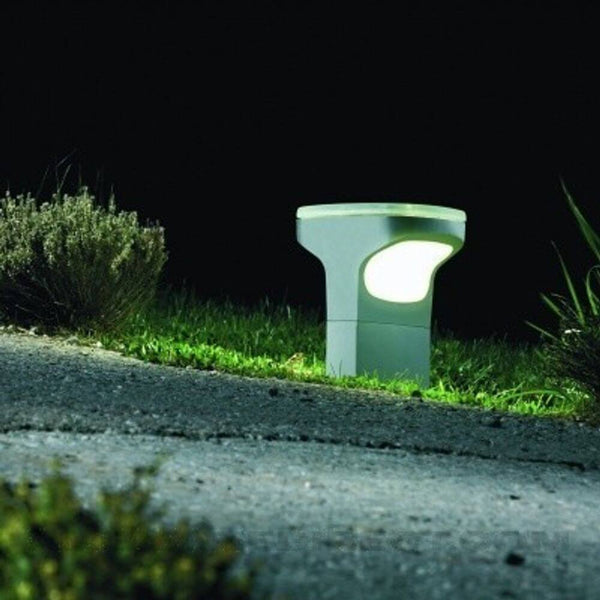 Luceplan Außen-Bodenleuchte Sky IP65 28cm leuchtet den Gartenweg in modernem Design bei Nacht.
