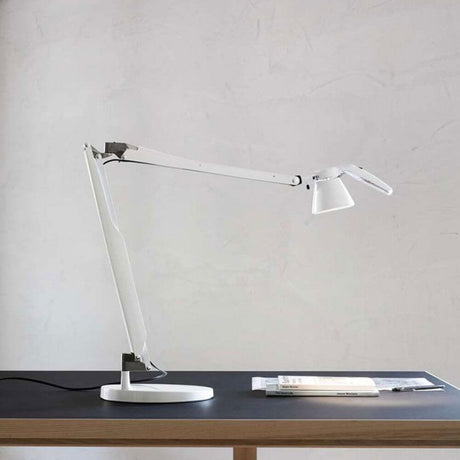 Luceplan Fortebraccio LED bord- og vegglampe (kropp) 3000K på et bord med dokumenter.
