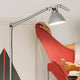 Luceplan Fortebraccio Stehlampe 92cm (Körper) leuchtet über einem modernen roten Sessel.