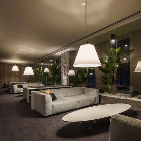 Luceplan Hängeleuchte Grande Costanza Ø 70cm in modernem Wohnzimmer mit eleganten Sofas und Pflanzen.