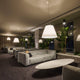 Luceplan Hängeleuchte Grande Costanza Ø 70cm in modernem Wohnzimmer mit eleganten Sofas und Pflanzen.