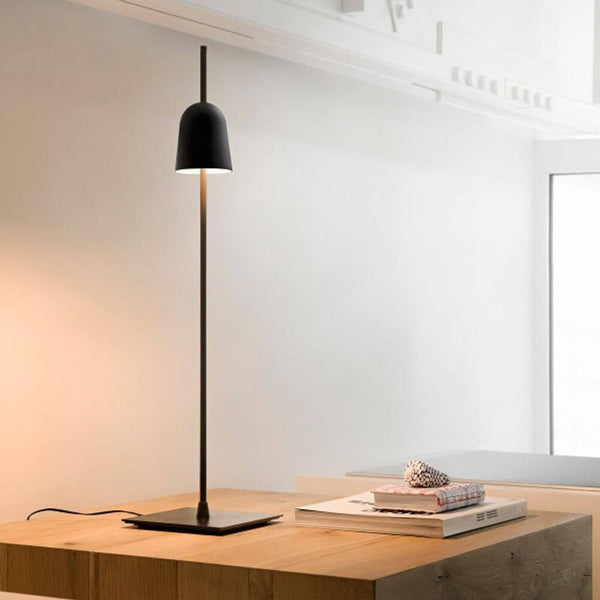 Luceplan LED Schreibtischlampe Ascent schwarz auf einem Holzstuhl, ideal für modernes Bürodesign.
