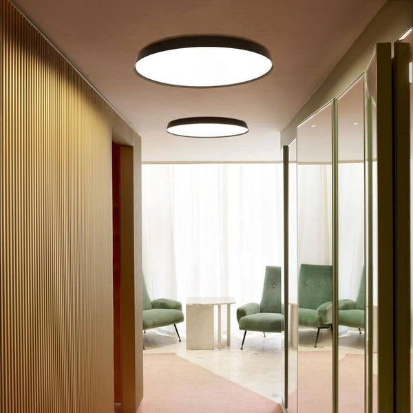 Luceplan LED Wand- & Deckenlampe Compendium Plate Ø 56cm in modernem Innenraum mit stilvollen Möbeln.