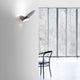Luceplan LED Wandlampe Garbi an einer Wand, modernes Design in einem hellen Raum mit Fenster und Stuhl.