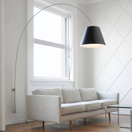 Luceplan Lady Costanza væglampe 215-248cm med alu lysdæmper over grå sofa i moderne rum.