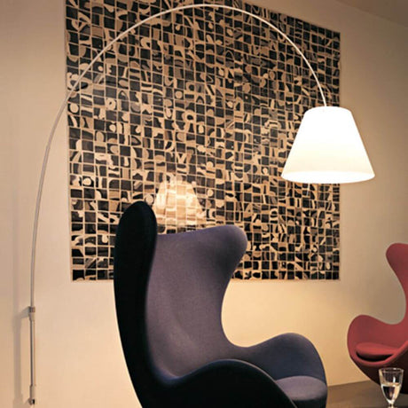 Luceplan Lady Costanza applique murale 215-248 cm alu à côté d’un fauteuil moderne dans une ambiance élégante.