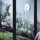 Luceplan Lightdisc LED Wand- und Deckenleuchte Ø 40cm an einer Wand mit Pflanzen im Hintergrund.