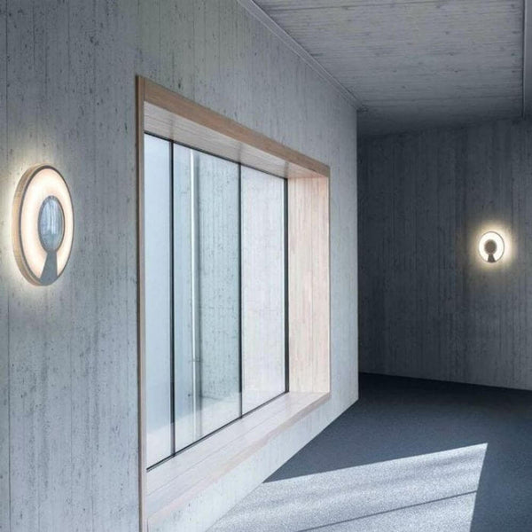 Luceplan Lightdisc LED wall and ceiling light Ø 40cm DALI dimmable IP65 in a modern room with wood and concrete.