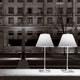 Zwei elegante Stehlampen im urbanen Umfeld bei Nacht, die moderne Beleuchtung repräsentieren.