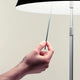 Hand, die den Sensor-Dimmer der Luceplan Stehlampe Costanza betätigt.