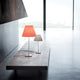Zwei elegante Luceplan Stehlampen Costanza mit konischem Schirm auf einem modernen Tisch im minimalistischen Raum.
