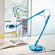 Luceplan Tivedo LED Büro-Tischlampe mit Präsenzsensor 3000K in blau auf einem Schreibtisch mit Buch