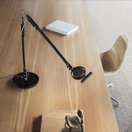 Luceplan Tivedo LED Büro-Tischleuchte 3000K auf einem Holzschreibtisch mit Modernem Stuhl.